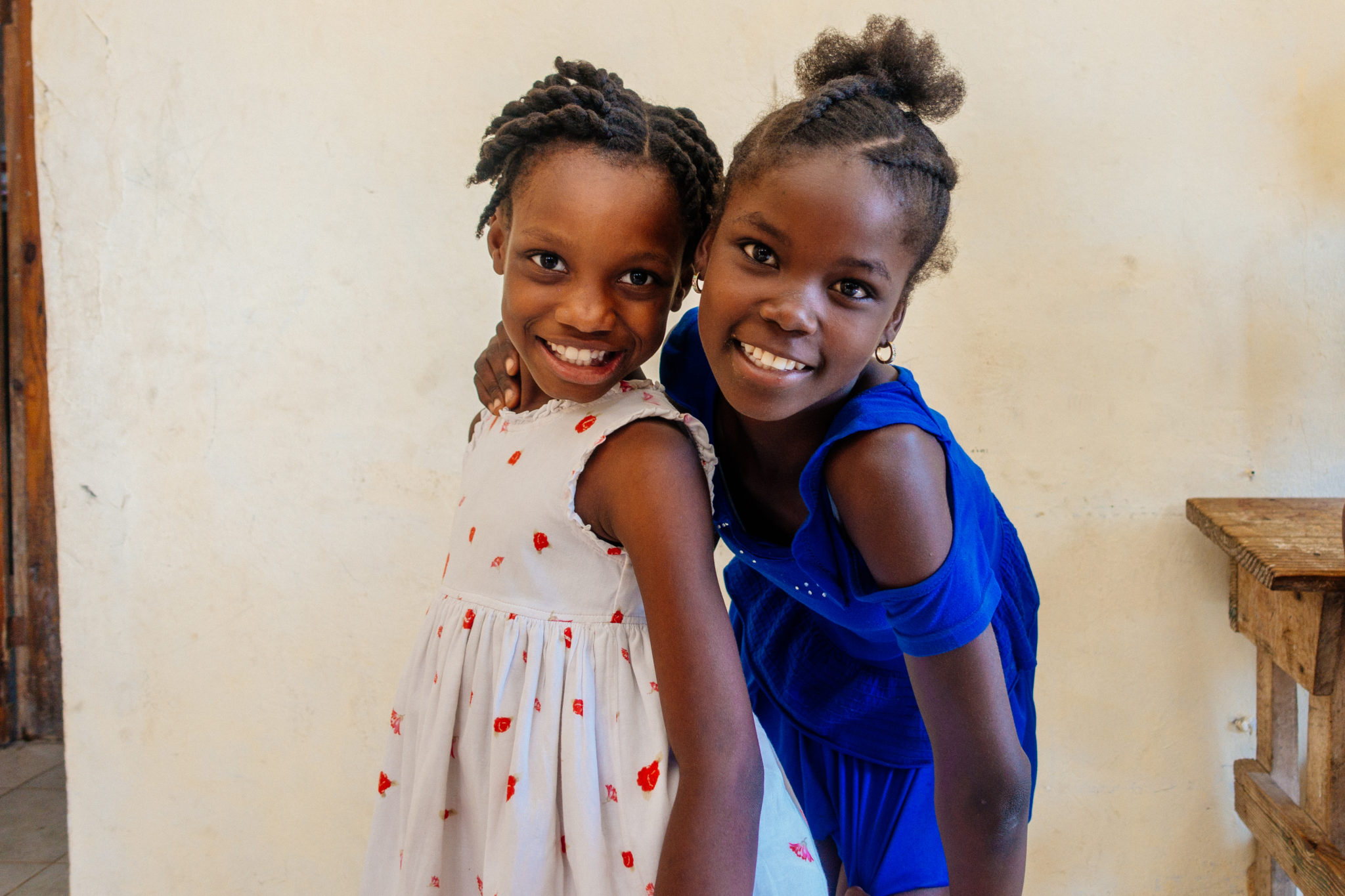 Two girls from the PAH home smiling with their arms around each other